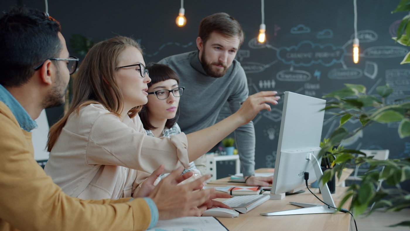 A team gathered around a single screen during a review.
